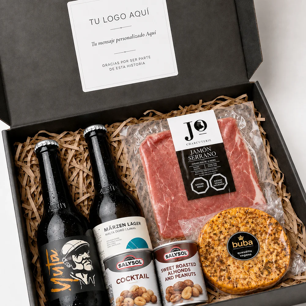 Alt: Caja Atacama con cervezas La Montaña Yuta y Märzen, jamón serrano, provoleta y latas SalySol de frutos secos en empaque corporativo.